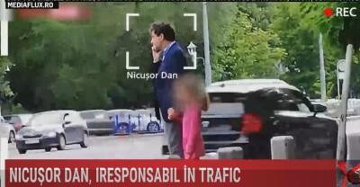 Nicușor Dan, filmat în timp ce trecea strada neregulamentar, cu copilul în brațe. Era cât pe ce să fie lovit de o mașină / Foto: Captură video Realitatea Plus